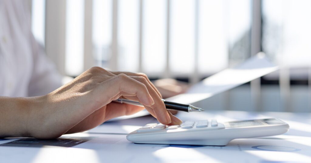 出品商品の査定額や販売利益を電卓で算出する様子